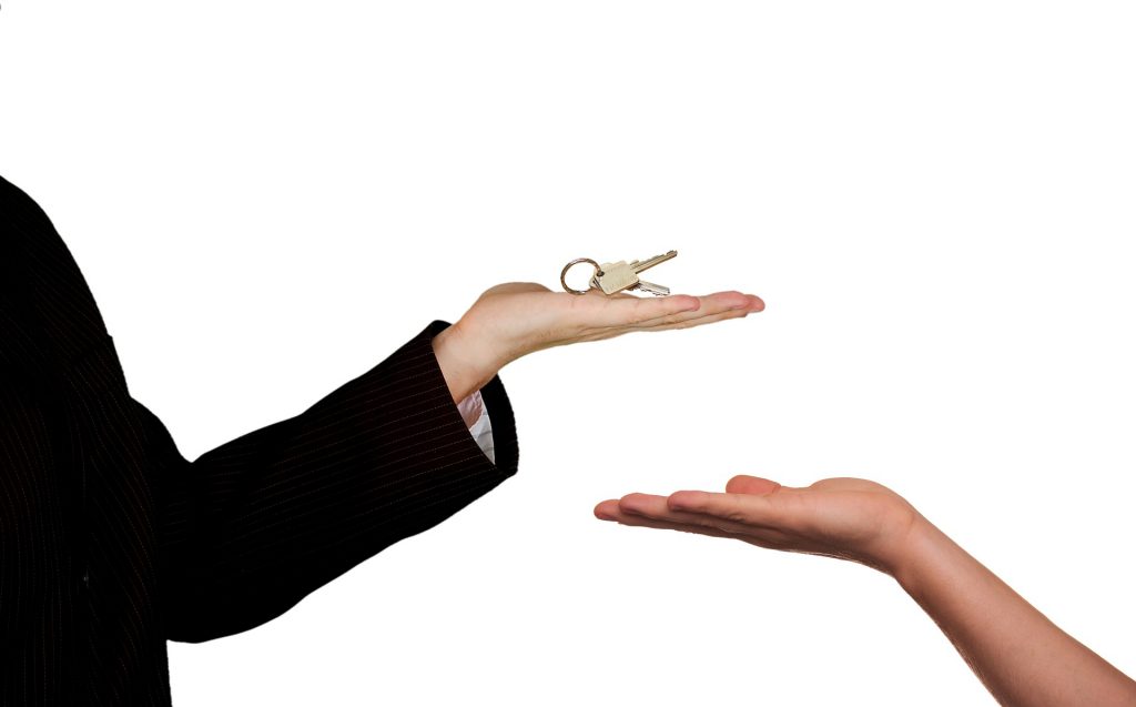 Un agent immobilier qui donne des clés à un locataire