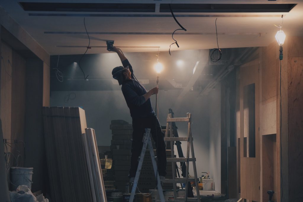 ouvrier dans une maison sur un escabeau