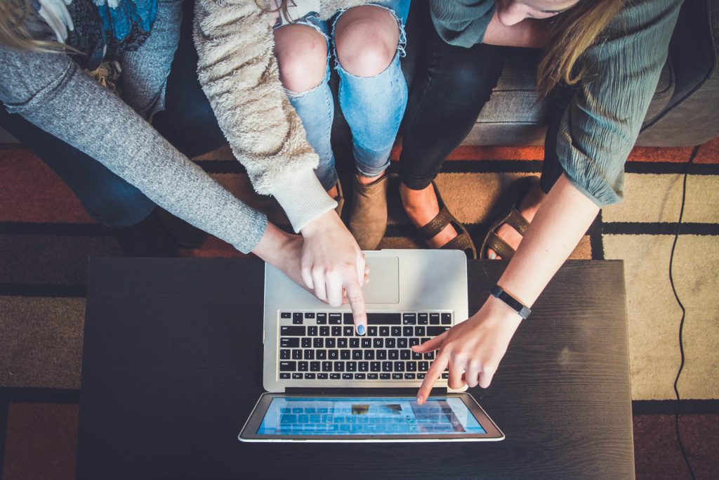 plusieurs personnes font un choix devant un pc portable